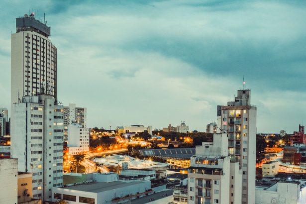 Vista panorâmica de Campinas ao entardecer, com edifícios iluminados e área urbana em destaque.